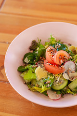 Vegetable salad with tomatoes, cucumbers and greens, flavoured with sesame and olive oil for a perfect vegan dinner