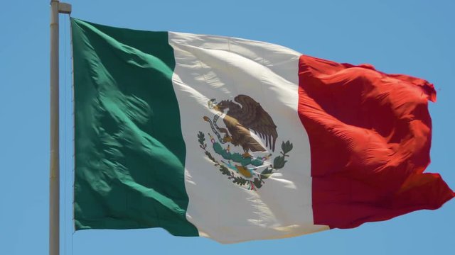 Mexican flag waving in the wind on bright sunny day