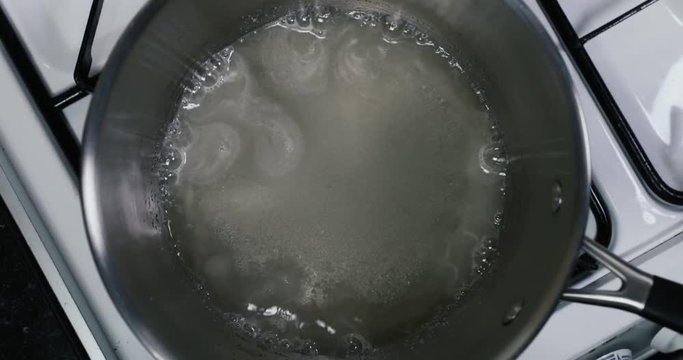 Shot of sugar and water boiling in a pan to make syrup for a tasty desert IN REVERSE &mdash; Sugar, Water - 4K shot at 60pfs