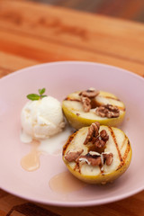 Sweet BBQ dessert: grilled apples with a nice scoop of vanilla ice cream on a light wooden table