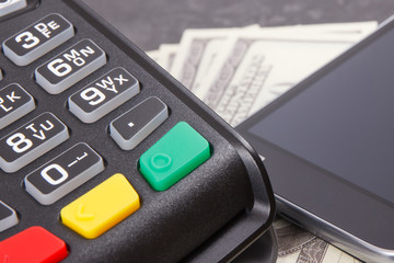 Obraz premium Payment terminal, money and smartphone with NFC technology using for cashless paying in different places