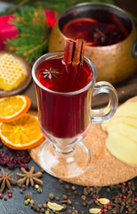 christmas hot mulled wine with cardamom and anise on wooden background