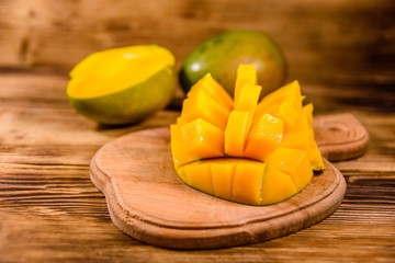 Cutting board with chopped mango fruit on a wooden table