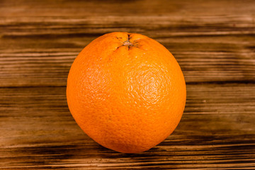 One orange fruit on a wooden table