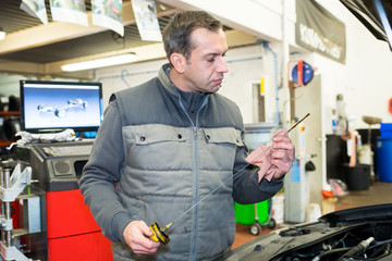 Fototapeta premium man pulling oil level gauge for check level of oi