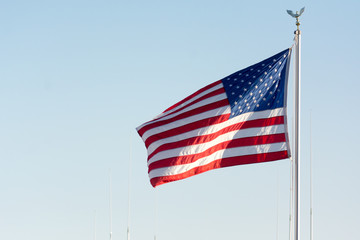American National Flag Blowing in the Wind on Blue Sky BAckground