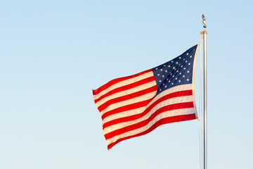 American National Flag Flitting in the Wind on Blue Sky BAckground