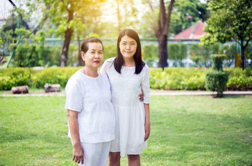 Portrait of a happy and smiling elderly asian woman with young women standing outdoor together