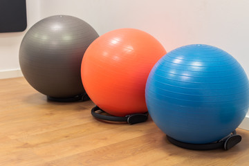 Fitness balls on wooden floor in the sport center. Exercise with gym balls. Gym for fitness exercises. Colorful fitness equipment on the floor
