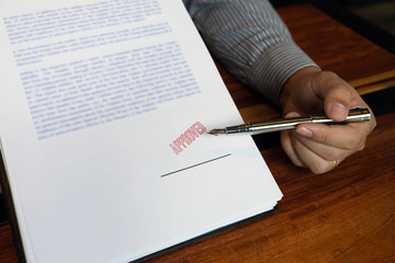 Close-up pictures of the hands of businessmen signing and stamping in approved contract forms