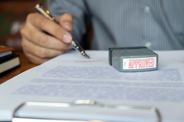 Close-up pictures of the hands of businessmen signing and stamping in approved contract forms