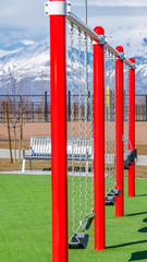 Vertical Swings on a playground with snow covered mountain in the background