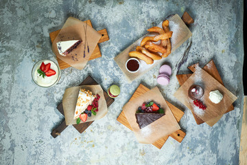 Assorted sweet desserts. Top view. Gray textured background. Beautiful serving dishes. Dessert. Food chain