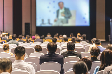 Obraz premium Rear view of Audience listening Speakers on the stage in the conference hall or seminar meeting, business and education about investment concept