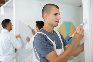 apprentice decorator using a paintbrush