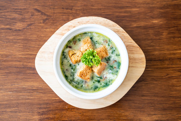 spinach soup with bread in white bowl