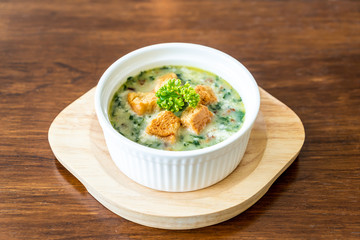 spinach soup with bread in white bowl