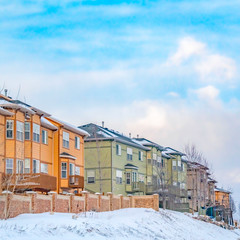 Fototapeta na wymiar Clear Square Scenic view of colorful houses on a snowy slope beside a paved road in winter