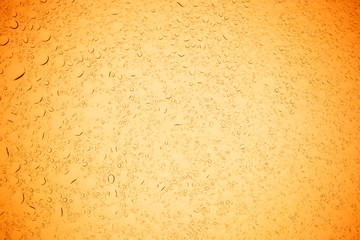 Rain droplets on yellow glass background, Water drops on yellow glass.