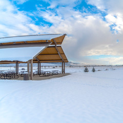 Square Square Expansive landscape blanketed with snow under a cloudy blue sky in winter under