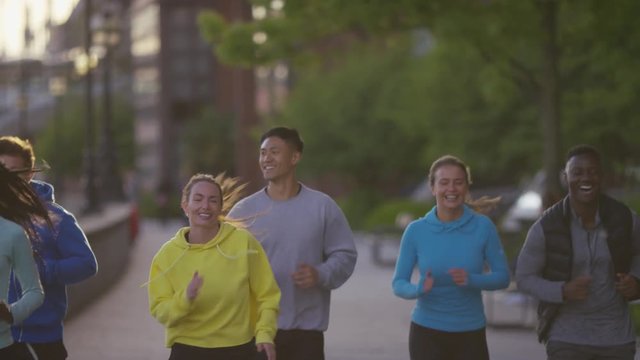 Diverse group of joggers running together, in slow motion