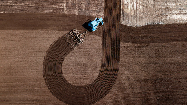 aerial view of tractor , combine cultivating field. drone shot. picture with space for text