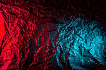 Texture of crumpled black paper. Close up black background of crumpled cardboard under color red...