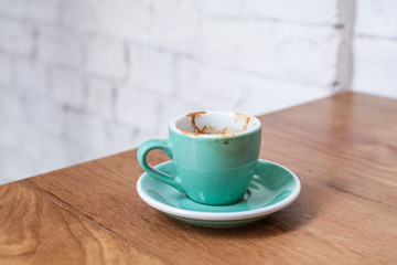 Empty coffee cup after drink on wood table light,empty coffee have spoon beside on the desk ,have a Magazine can read in the morning,beautyful light