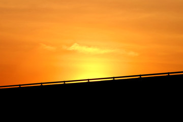 Silhouette traffic barrier of highway with background of dusk sky during sunset