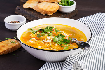 Red lentil soup with chicken meat and vegetables close-up on the table. Healthy food.