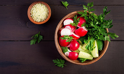 Fresh salad of cucumbers, radishes, onion and herbs. Buddha bowl. Flat lay. Top view