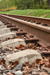 Children narrow gauge railway. Rails and sleepers on the background of the land and green grass. Close-up