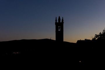 The silhouette of a church in Tuscany, at dusk