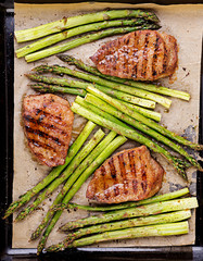 Barbecue grilled beef steak meat with asparagus and herbs. Top view