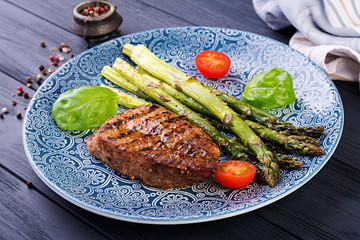 Barbecue grilled beef steak meat with asparagus and tomato.
