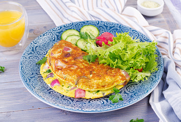 Breakfast. Omelette with radish, red onion and fresh salad on blue plate.  Frittata - italian omelet.