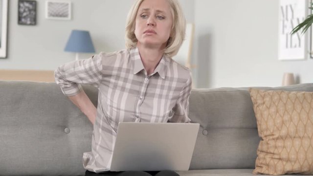 Old Woman with Back Pain Working on Laptop