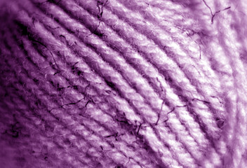 Yarn ball close-up with blur effect in purple color.