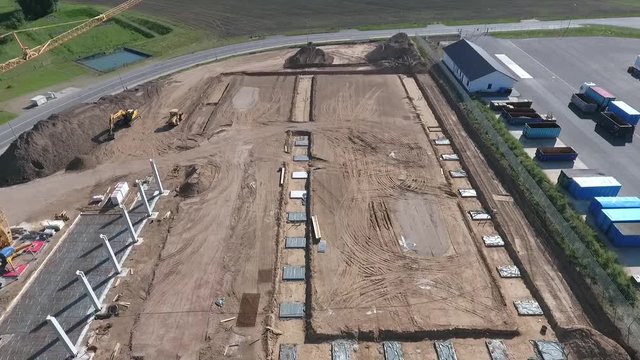 A drone flies over a large construction site on which a huge production hall is being built