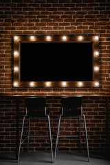 A makeup mirror with light bulbs  and wooden frame on a brown brick wall background with black space for text inside 