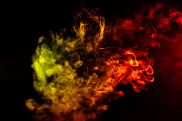 Beautiful horizontal column of smoke in the neon bright light of red, green, yellow and orange on a black background exhaled out of the vape. Nice pattern for printing and backdrop of colored waves.