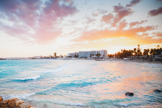 A delightful gentle sunset on the blue sea coast with hotels in pastel shades