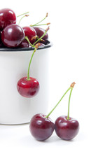 White cup with red sweet cherry isolated on a white background..