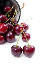 White cup with red sweet cherry isolated on a white background..