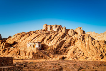 Fototapeta premium Egyptian mountains and old small hut with bly sky.