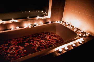 a bath filled with rose petals by candlelight is romantic