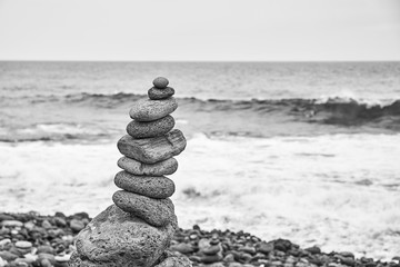 Black and white picture of a stone stack on a beach.