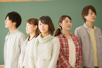 黒板の前に並ぶ大学生