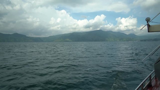 Lake Toba ferry boat ride to get to Samosir island from Parapat to Tuk Tuk (Beautiful clouds and mountains in the background). Seq 3
