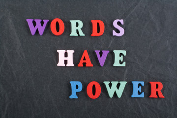 Obraz premium WORDS HAVE POWER word on black board background composed from colorful abc alphabet block wooden letters, copy space for ad text. Learning english concept.